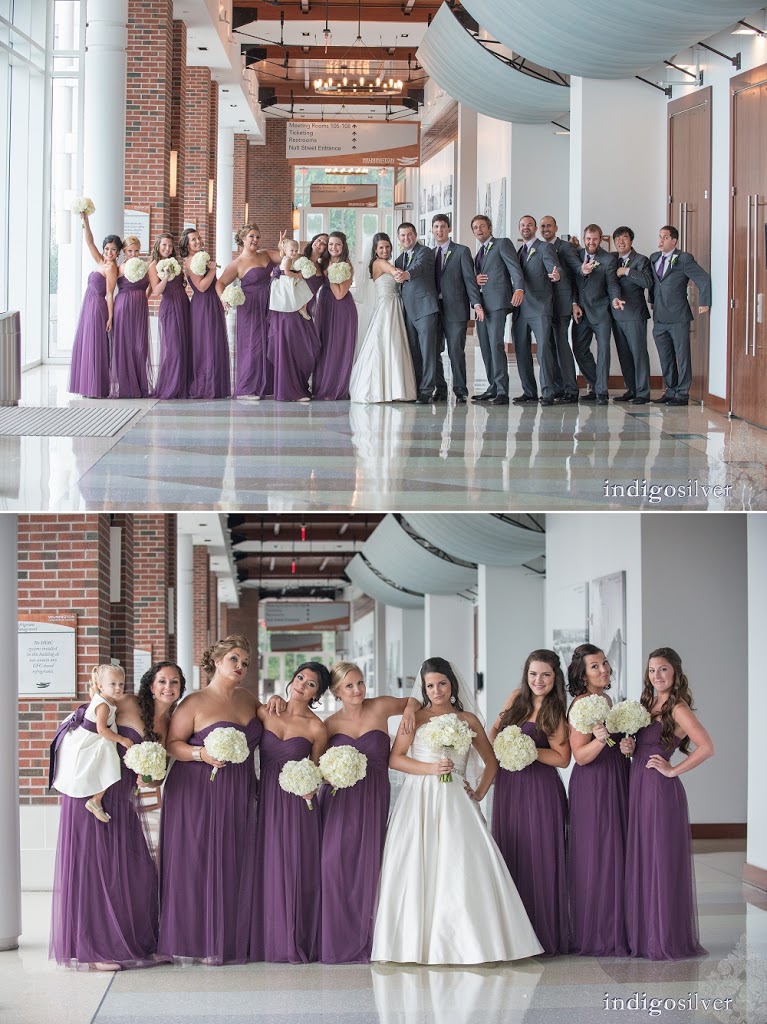 Wedding party posed in a bright interior corridor, with the bride in a white gown, bridesmaids in purple dresses holding white bouquets, and groomsmen in gray suits shown in two stacked group photos.